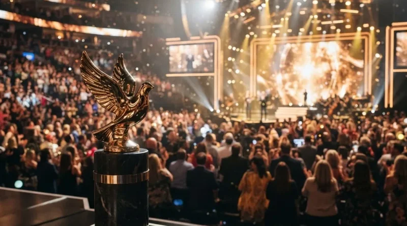 Golden dove-shaped trophy on a pedestal inside a Nashville arena with gold and white stage lighting